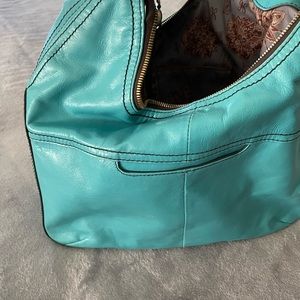 Hobo turquoise handbag, polished leather, glossy. Brushed antique hardware.